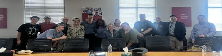 Group of people posing in a conference room.